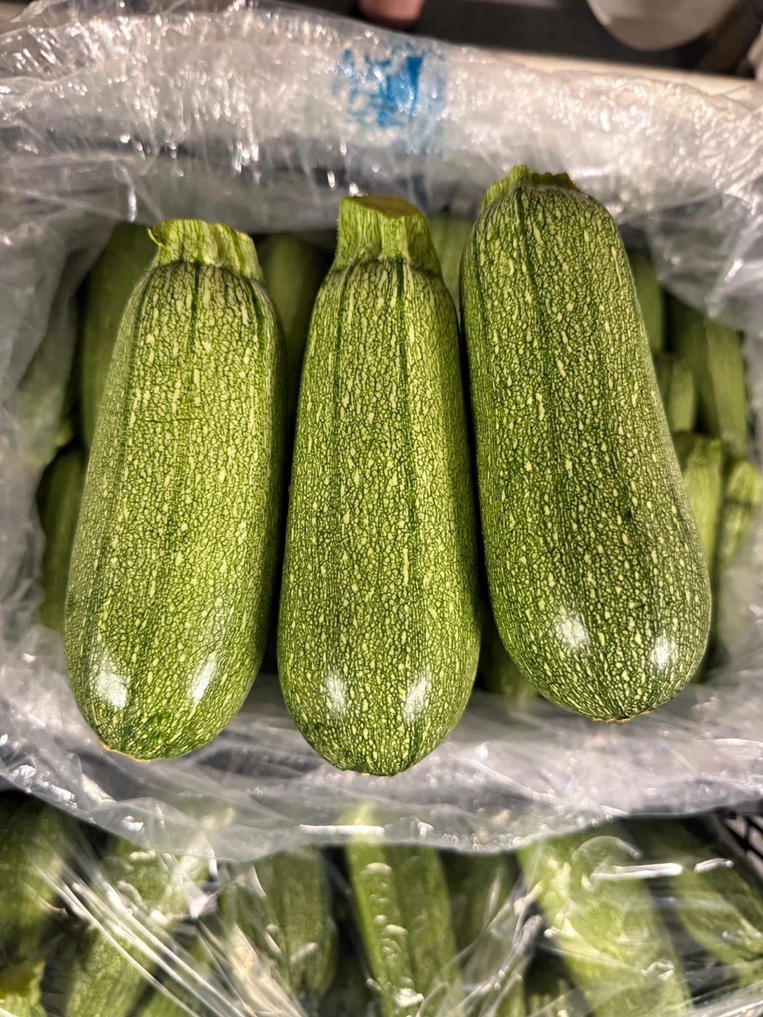 Three grey squash over a produce crate